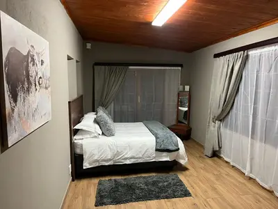 a bedroom with a bed and a large window at 72 on Devenish in Polokwane