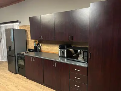 a kitchen with wooden cabinets and a stainless steel refrigerator at 72 on Devenish in Polokwane