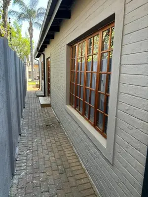 a brick sidewalk next to a building with windows at 72 on Devenish in Polokwane