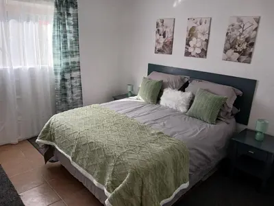 a bedroom with a bed with a green comforter at The Garden Cottage in Polokwane