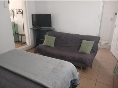 a living room with a couch and a tv at The Garden Cottage in Polokwane