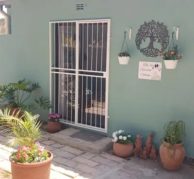 a door with potted plants on the side of a house at The Garden Cottage in Polokwane