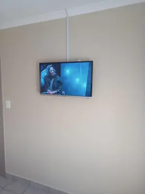 a television on top of a white wall at Tranquil heights Inn in Centurion