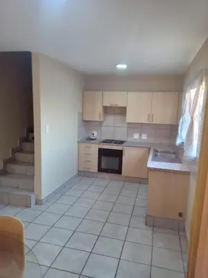 a kitchen with a stove top oven next to a staircase at Tranquil heights Inn in Centurion