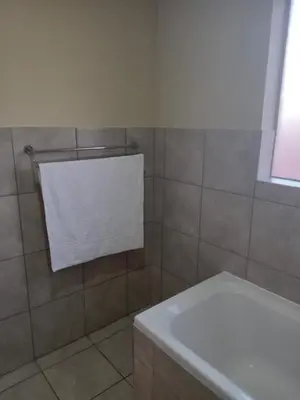 a bathroom with a bath tub and a white towel at Tranquil heights Inn in Centurion