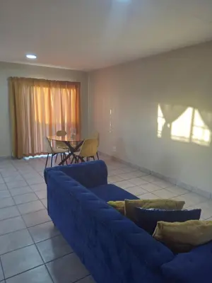 a living room with a blue couch and a table at Tranquil heights Inn in Centurion