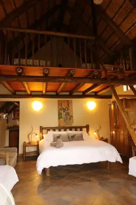 a bedroom with a large white bed in a room at Tanda Kutula Mountain Lodge in Guthrie