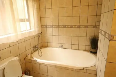 a bathroom with a tub and a toilet at Tanda Kutula Mountain Lodge in Guthrie