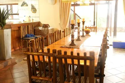 a dining room with a wooden table and chairs at Tanda Kutula Mountain Lodge in Guthrie