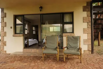 two chairs sitting in front of a building at Tanda Kutula Mountain Lodge in Guthrie