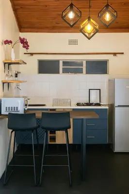 a kitchen with a counter and two stools in it at Panaroma View in Graskop