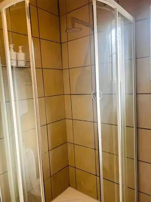 a shower with glass doors in a bathroom at Panaroma View in Graskop