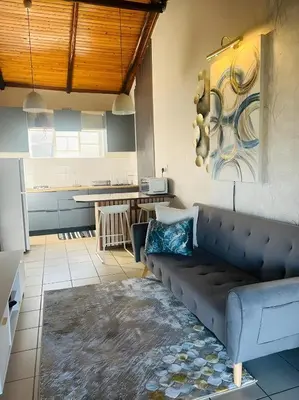 a living room with a couch and a kitchen at Panaroma View in Graskop