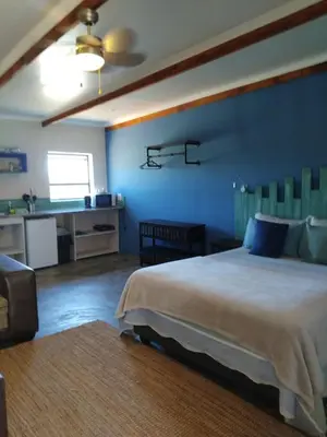 a bedroom with a large bed and a desk at At Skywalkers in Skeerpoort