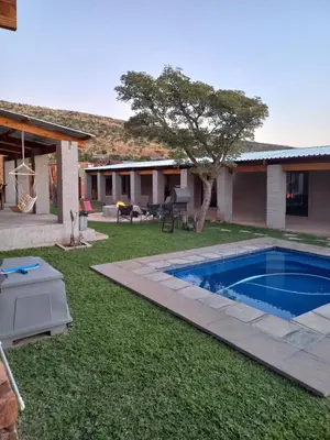 a yard with a swimming pool and a house at At Skywalkers in Skeerpoort