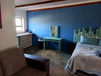 a blue bedroom with a bed and a mirror at At Skywalkers in Skeerpoort