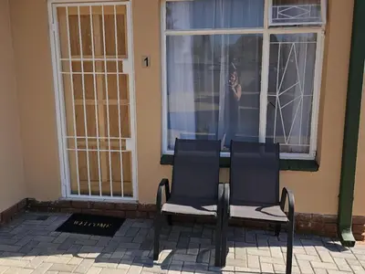 a couple of chairs sitting in front of a window at Protea Guesthouse in Middelburg