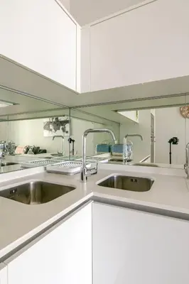 a kitchen with two sinks and white cabinets at Shapz at Ellipse-Waterfall in Midrand