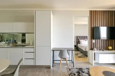 a kitchen and living room with a table and a bed at Shapz at Ellipse-Waterfall in Midrand