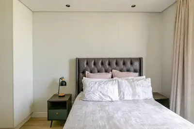 a bedroom with a large bed with pink pillows at Shapz at Ellipse-Waterfall in Midrand