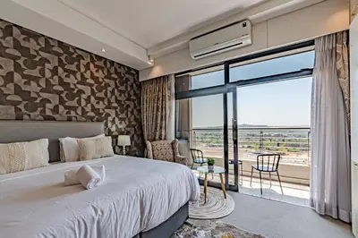 a bedroom with a large bed and a large window at 1403 Menlyn Maine Trilogy in Pretoria