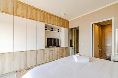 a bedroom with a white bed and a television at 1403 Menlyn Maine Trilogy in Pretoria