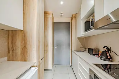 a kitchen with white cabinets and a counter top at 1403 Menlyn Maine Trilogy in Pretoria