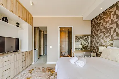 a bedroom with a large bed and a tv at 1403 Menlyn Maine Trilogy in Pretoria