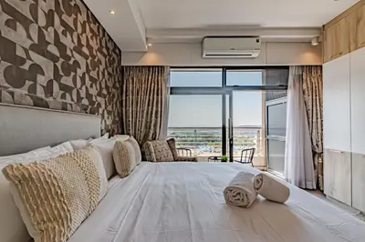a bedroom with a large bed with a large window at 1403 Menlyn Maine Trilogy in Pretoria