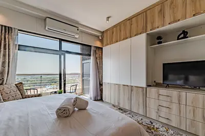 a bedroom with a large bed and a large window at 1403 Menlyn Maine Trilogy in Pretoria