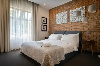 a bedroom with a bed and a brick wall at Iconyc Apartment in Brentwood Park