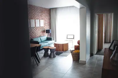 a living room with a blue couch and a table at Iconyc Apartment in Brentwood Park