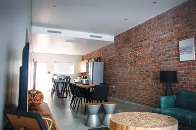 a living room with a brick wall at Iconyc Apartment in Brentwood Park