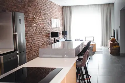 a kitchen with a counter and a brick wall at Iconyc Apartment in Brentwood Park