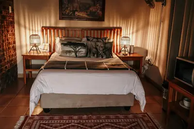 a bedroom with a large bed with two night stands at A Traveller's Palm in Phalaborwa