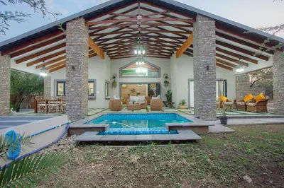 a house with a swimming pool in the yard at Edjami Lodge in Marloth Park
