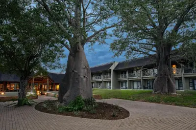 a building with two large trees in front of it at aha Skukuza Safari Lodge in Skukuza