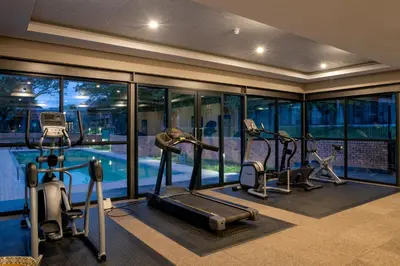 a gym with three treadmills and a swimming pool at aha Skukuza Safari Lodge in Skukuza