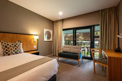 a hotel room with a bed and a desk and a chair at aha Skukuza Safari Lodge in Skukuza