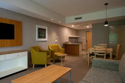 a waiting room with yellow chairs and a table at aha Skukuza Safari Lodge in Skukuza