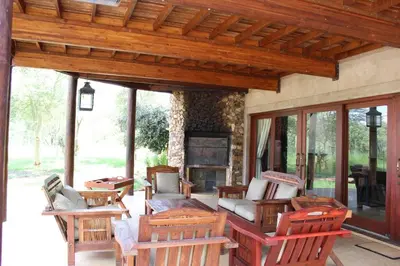 a patio with chairs and a couch and a fireplace at Zebula Lodge 132 in Mabula