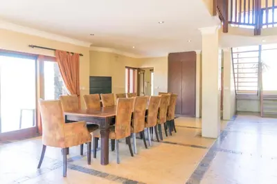 a dining room with a wooden table and chairs at Zebula Lodge 132 in Mabula