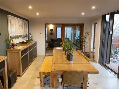 a living room with a wooden table and chairs at Ntoma House in Hoedspruit