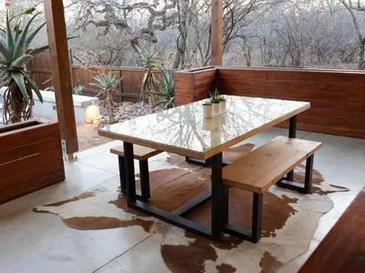 a table and a bench on a patio at Ntoma House in Hoedspruit