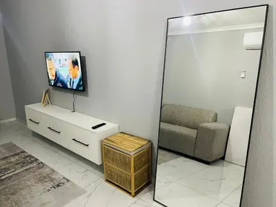 a living room with a mirror and a couch at Tranquil Unit in Phalaborwa