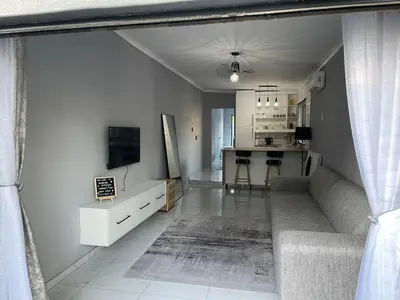 a living room with a couch and a kitchen at Tranquil Unit in Phalaborwa