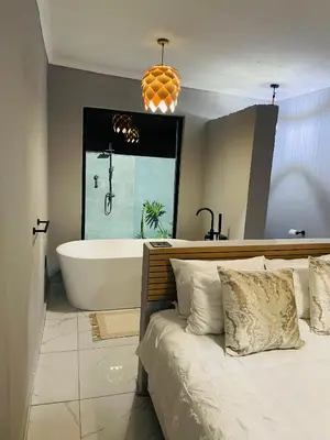 a bathroom with a tub and a bed and a bath tub at Tranquil Unit in Phalaborwa