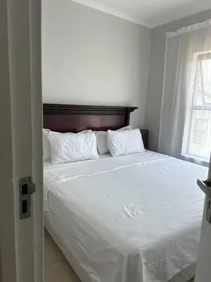 a bedroom with a large bed with white sheets and pillows at Irenes home of nature in Nelspruit