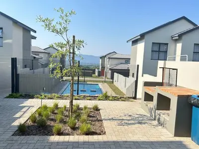 a courtyard with a tree and a swimming pool at Irenes home of nature in Nelspruit