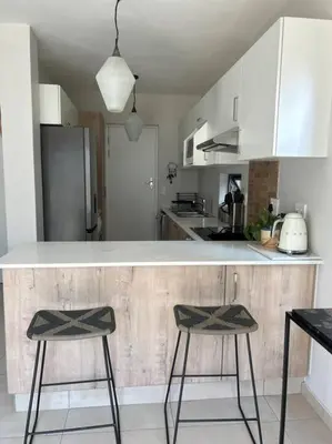 a kitchen with two bar stools in front of a counter at Irenes home of nature in Nelspruit